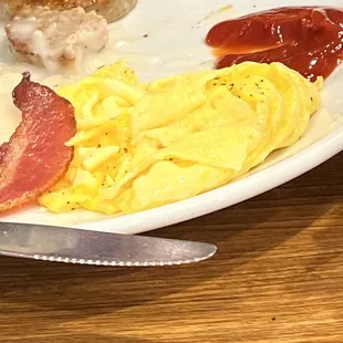 a plate of eggs, bacon, and sausage