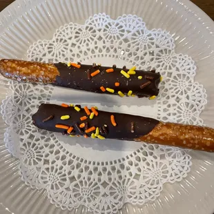 two chocolate covered pretzels on a plate