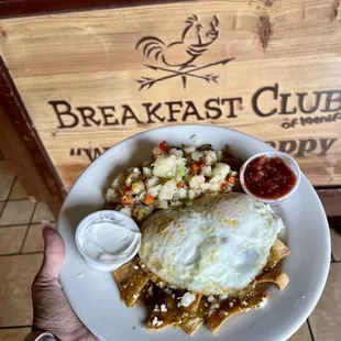 Green Chilaquiles, over medium eggs, Club potatoes and Homemade salsa with sour cream.
