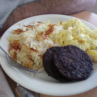 a plate of eggs, hash browns, and a burger