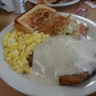 a plate of food with eggs, toast, and gravy