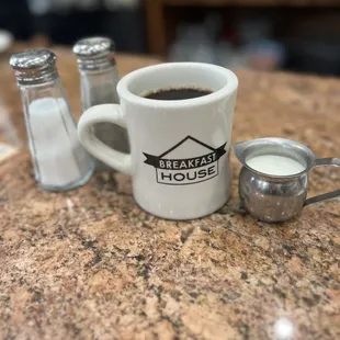 a cup of coffee and salt shakers