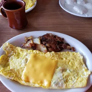 an omelet, bacon, hash browns, and a cup of coffee
