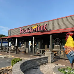 the front of a restaurant with a rooster statue