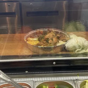 Chicken over rice , carrots and onions and peppers.