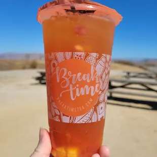 a hand holding a cup of iced tea