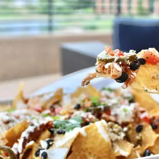 The House Smoked Chicken Nachos are made with smoked chicken, corn chips, BB ale nacho cheese, pico-de-gallo, sour cream and jalapeño