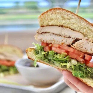 The Chicken Sandwich is made with grilled marinated chicken breast, lettuce, tomato and basil pesto.
