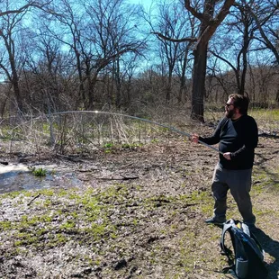 Disc golf course. Feb 2024.  Fishing for his disc.