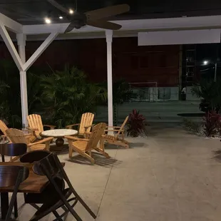 a patio with chairs and a ceiling fan