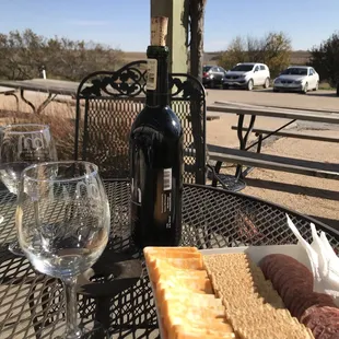 a table with wine, cheese and crackers