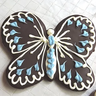 Butterfly cookie dipped in dark and decorated with white chocolate