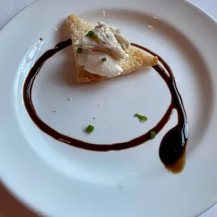 Amuse-bouche: limp crabmeat on toast point with balsamic vinegar.