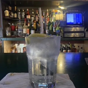 a glass of ice with a lemon wedge