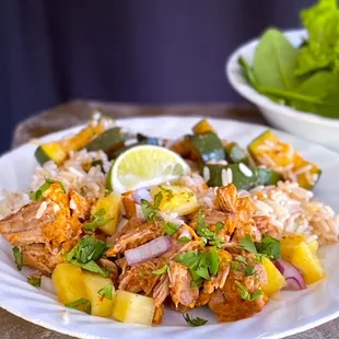a plate of chicken, rice, and pineapple salad