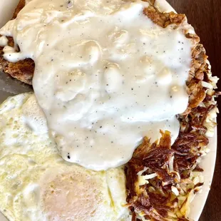 a plate of hash browns, eggs, and gravy