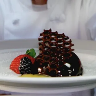 a chef holding a plate of food