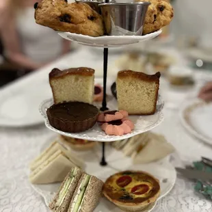 Scones and cream on top layer, sweets on middle layer and tea sandwiches and tart