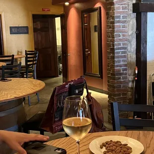 a woman sitting at a table with a glass of wine
