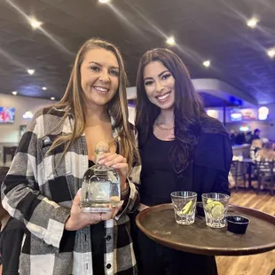 two women holding drinks