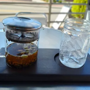 a glass of water and a pitcher on a table