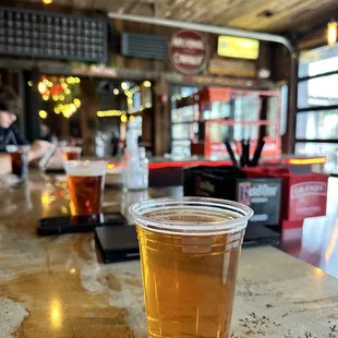 Indoor/outdoor patio bar and Bumble berry draft beer in plastic cup