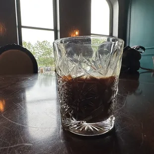 a glass of iced coffee on a table