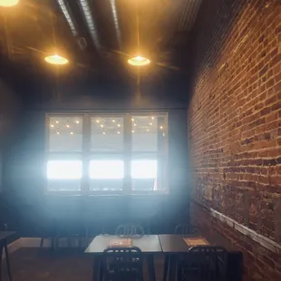 a brick wall and tables in a coffee shop