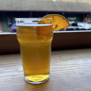 a glass of beer with a slice of orange