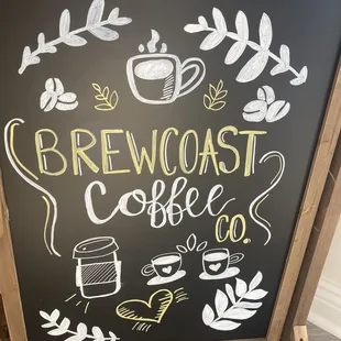 a chalkboard sign with a cup of coffee