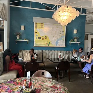 a group of people sitting at tables in a coffee shop