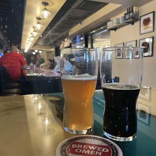 two glasses of beer on a bar