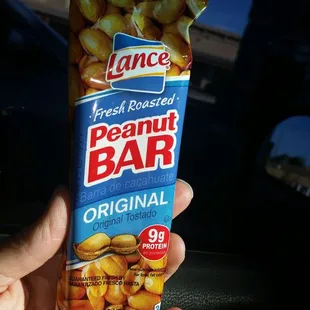 a hand holding a packet of peanut bar