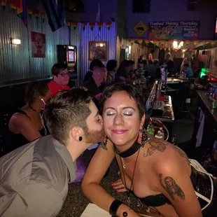 a man kissing a woman at a bar