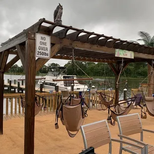 a view of a dock with swings and chairs