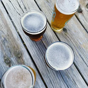 four glasses of beer on a wooden table