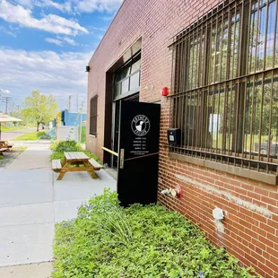 a black refrigerator in front of a brick building