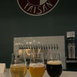 three glasses of beer on a bar