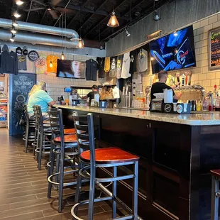 a bar with stools and a television