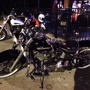 two motorcycles parked in front of a fence