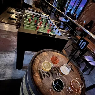 a foosball table with beer glasses on it