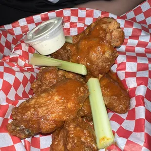 a basket of chicken wings and celery