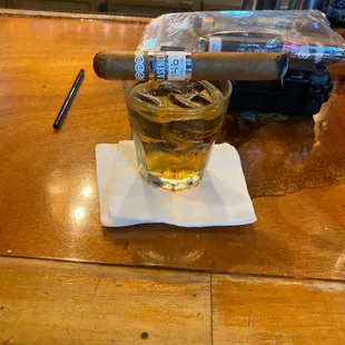 a glass of whiskey and a cigar