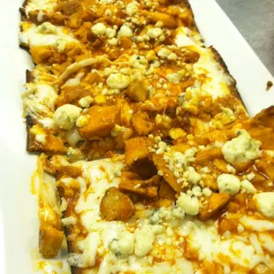 Buffalo chicken flatbread pizza. Buffalo sauce, chicken, smoked provolone and mozzarella mixed cheese, blue cheese crumbles.