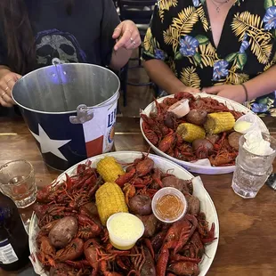 two people sitting at a table with plates of food