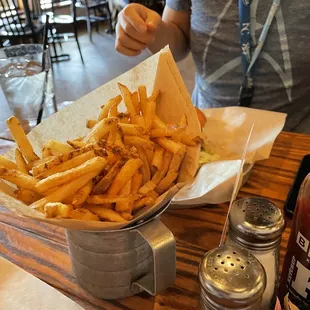 a basket of french fries and a bottle of ketchup