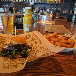 STEAKHOUSE wagyu burger and killer tots with dipping sauce.