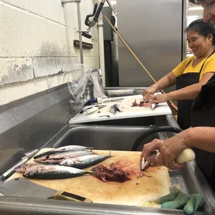 a woman cutting fish