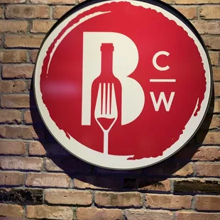 a red and white sign on a brick wall