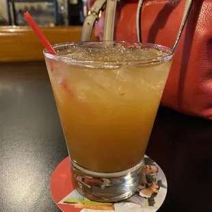 a glass of orange juice with a straw